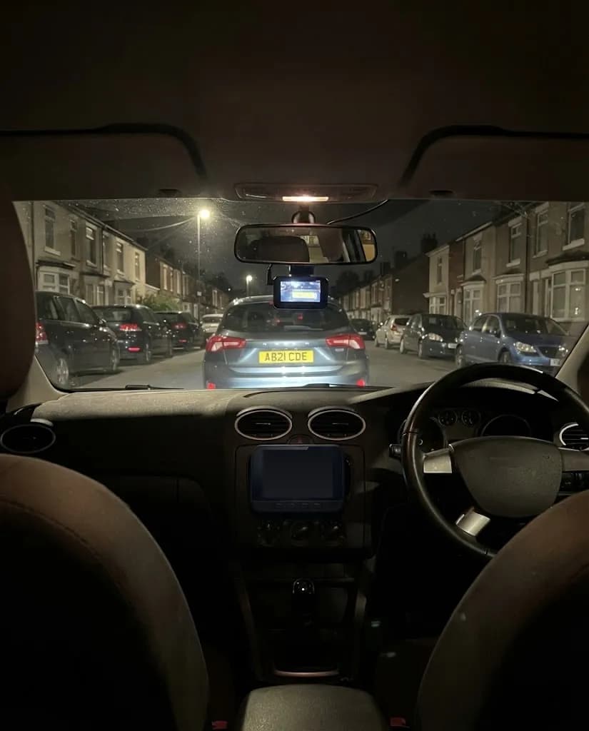 A wet street at night through the windscreen, the Halden Duo 4K behind the mirror