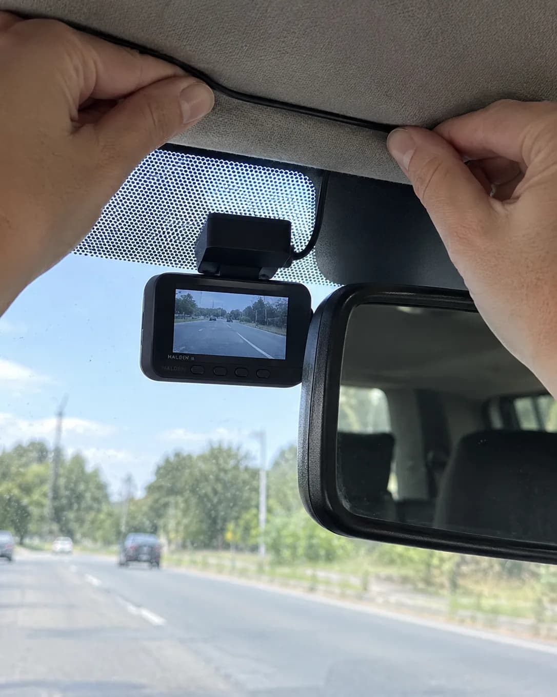 The small Halden camera tucked behind the mirror, its cable hidden in the roof lining